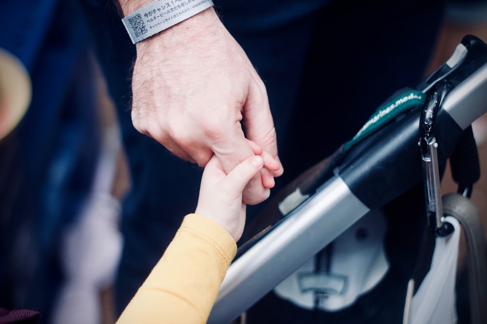 person holding hands with child