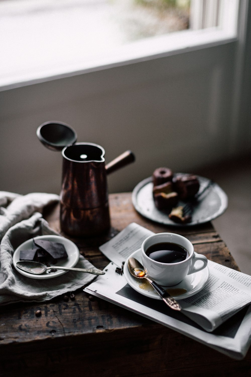 茶色の木製のテーブルに白いセラミックのマグカップに入ったコーヒー