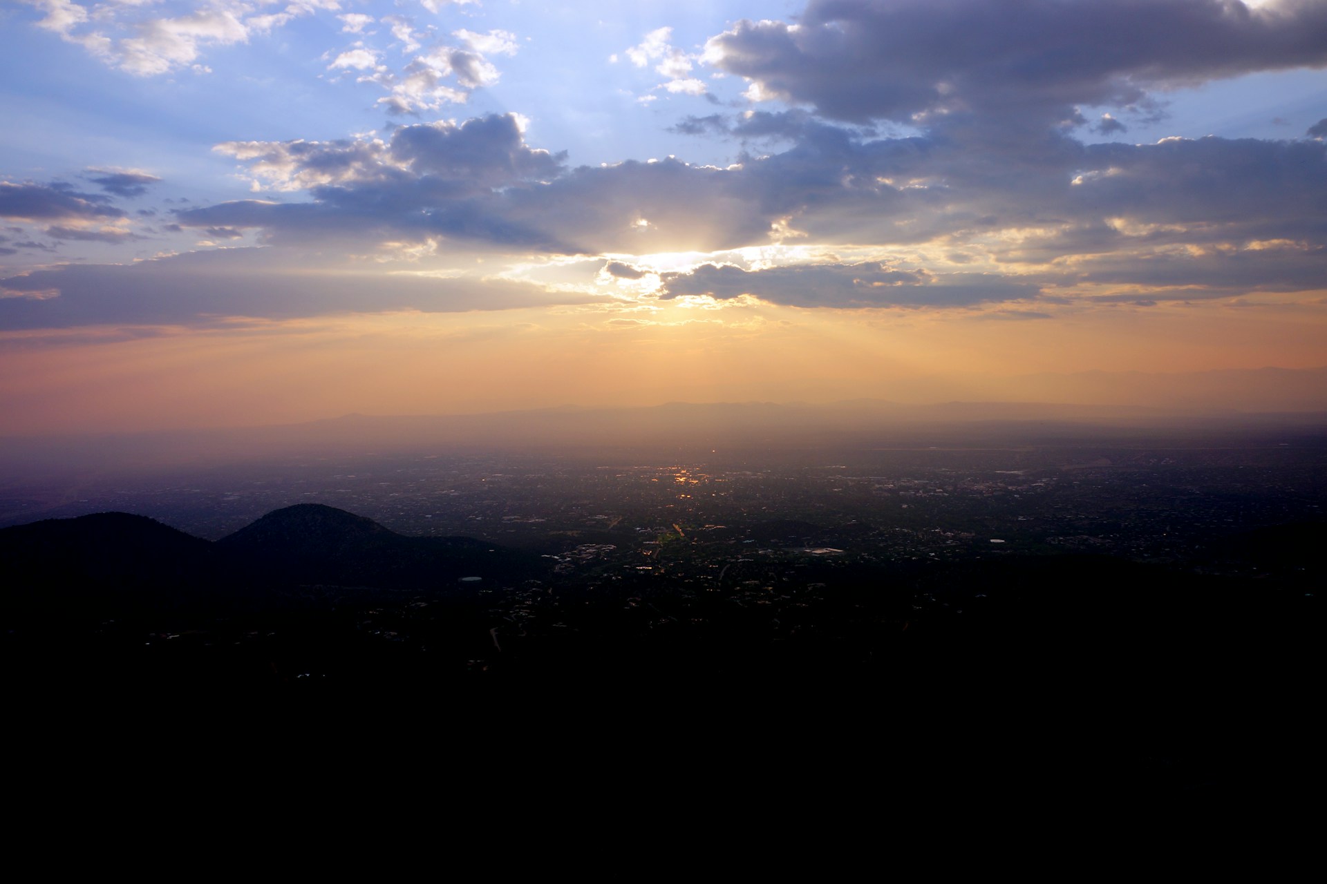 A stunning 4K shot of a golden sunset over the historic cityscape of San Miguel de Tucumán, with soft white and gold tones reflecting the brand colors.