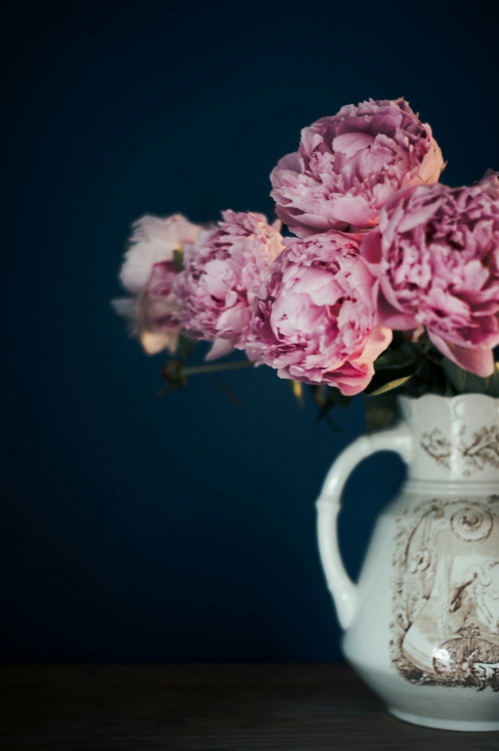 pink flower on white pitcher