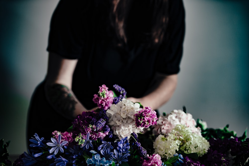 white and pink flower bouquet in front of man