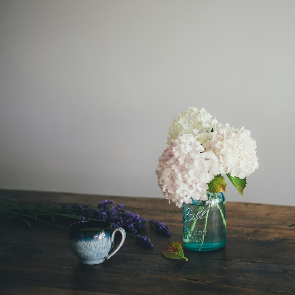 white flowers on green glass vase