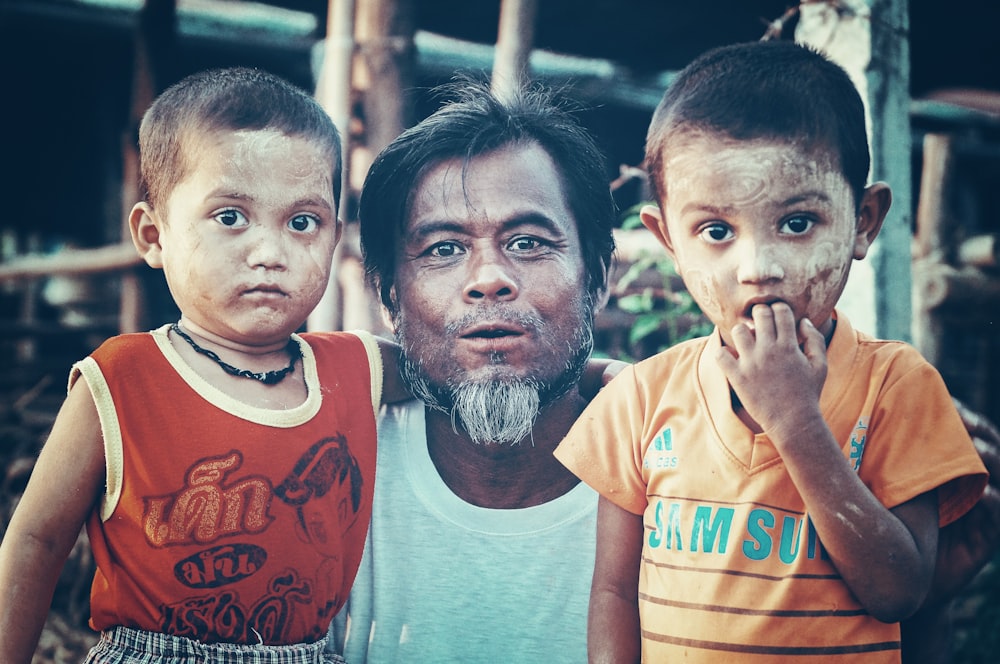 man standing between two boys