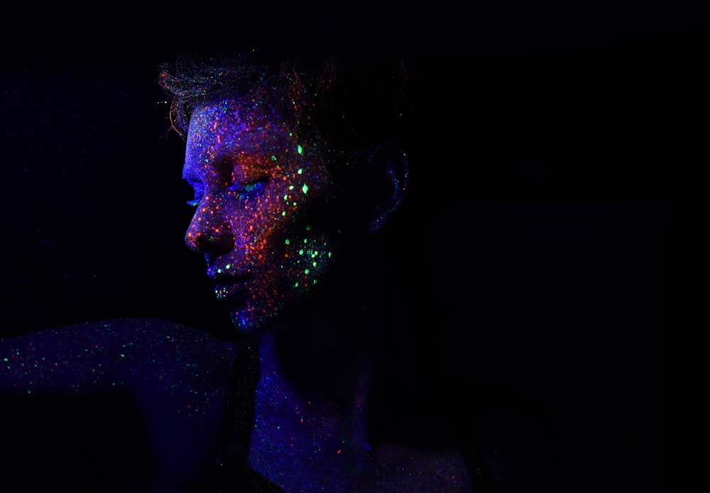 Person im dunklen Hintergrund mit Galaxieneffekten im Gesicht