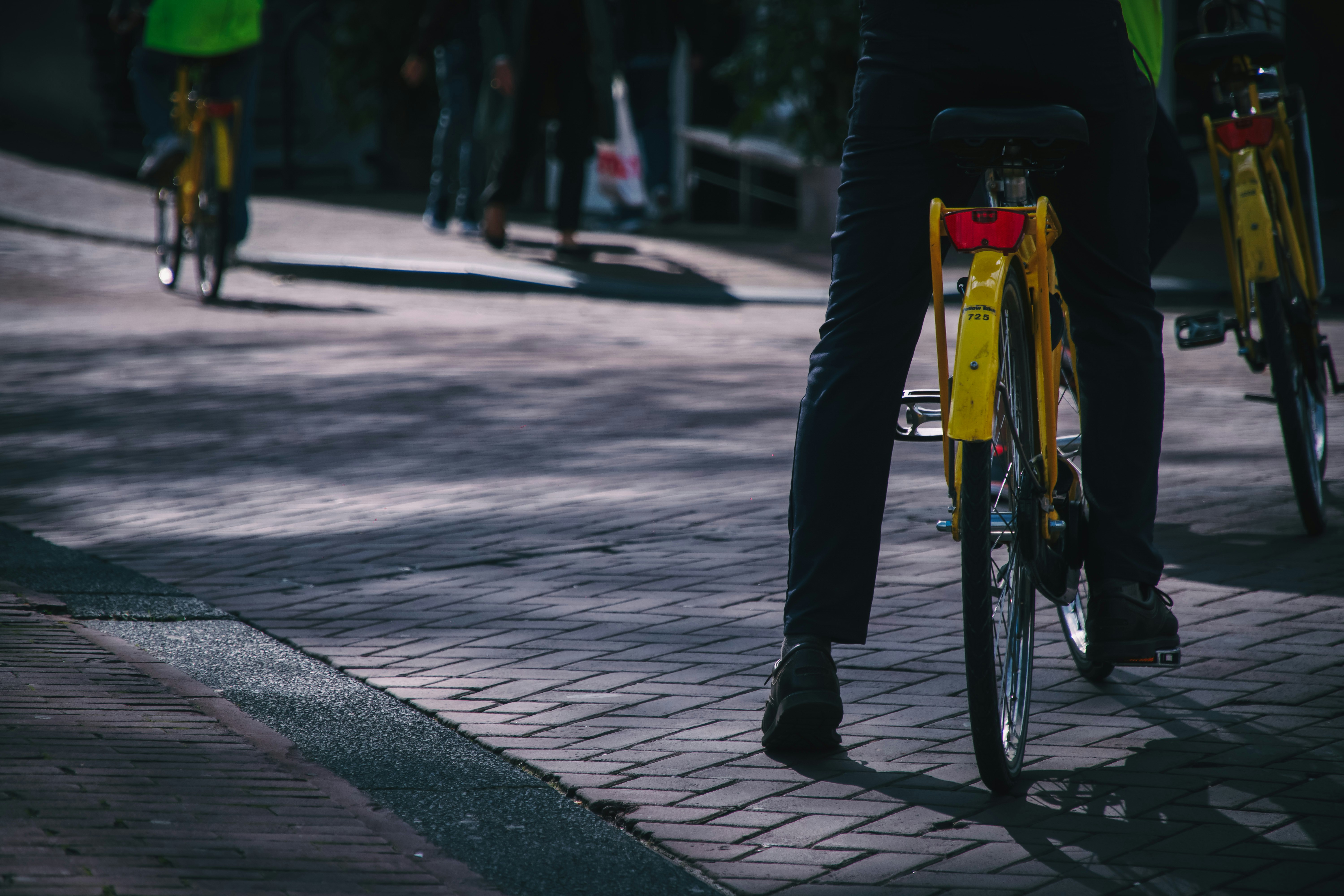 person riding on yellow bicycle during daytime