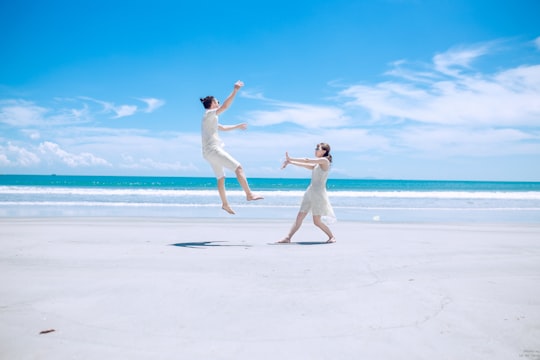 man and woman playing on white sand near seashore during daytime in Da Nang Vietnam