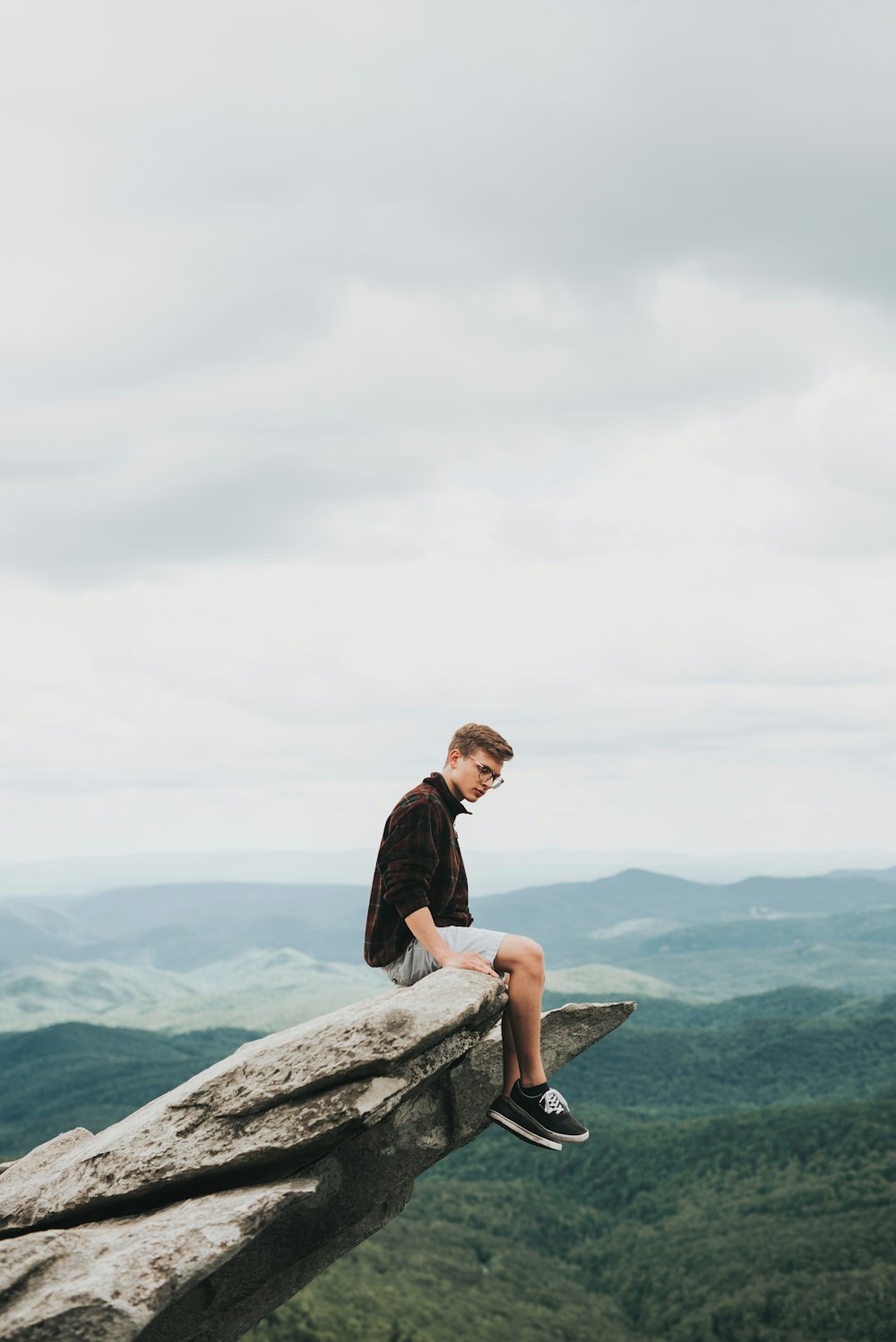 man sitting on the edge of stone