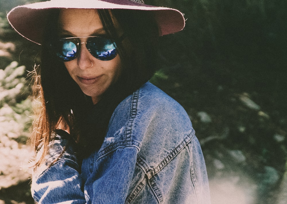 woman in denim jacket wearing shades