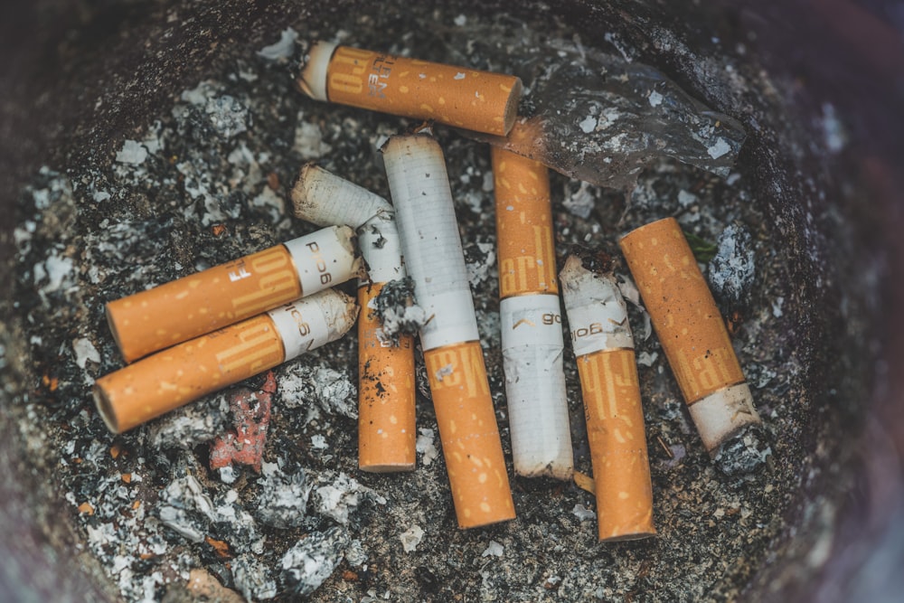 closeup photo of cigarette on ashtrays