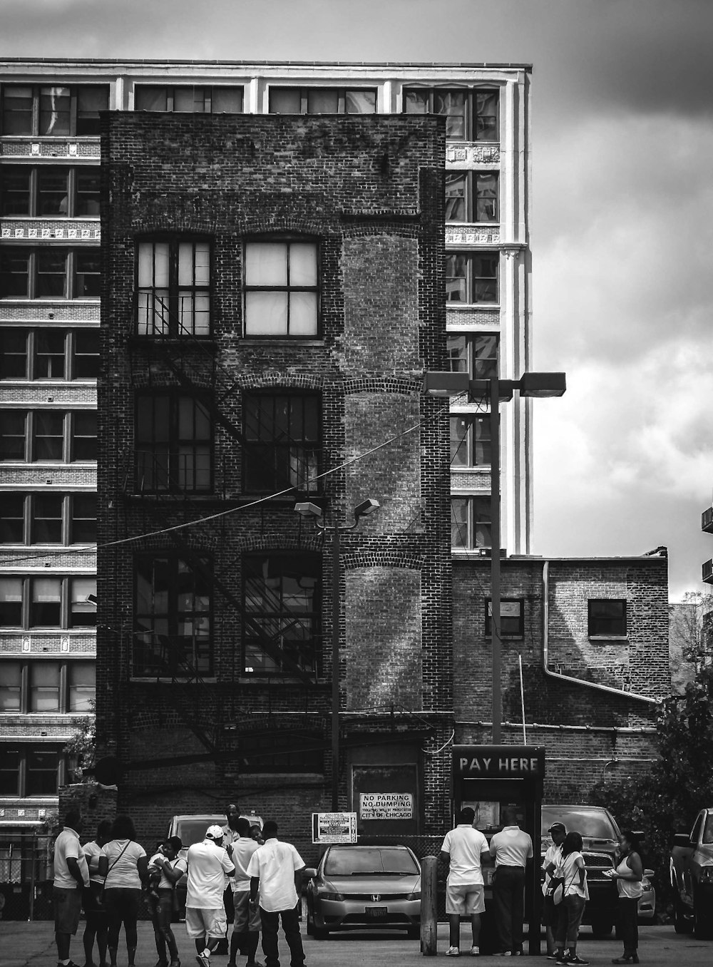 grayscale photo of people facing building
