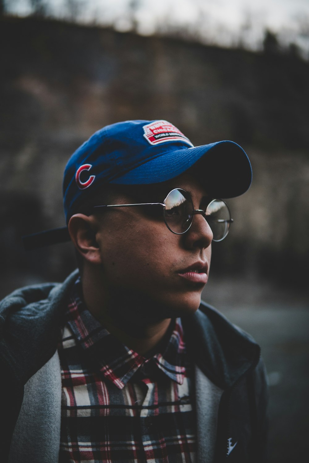 shallow focus photography of man wearing blue fitted cap