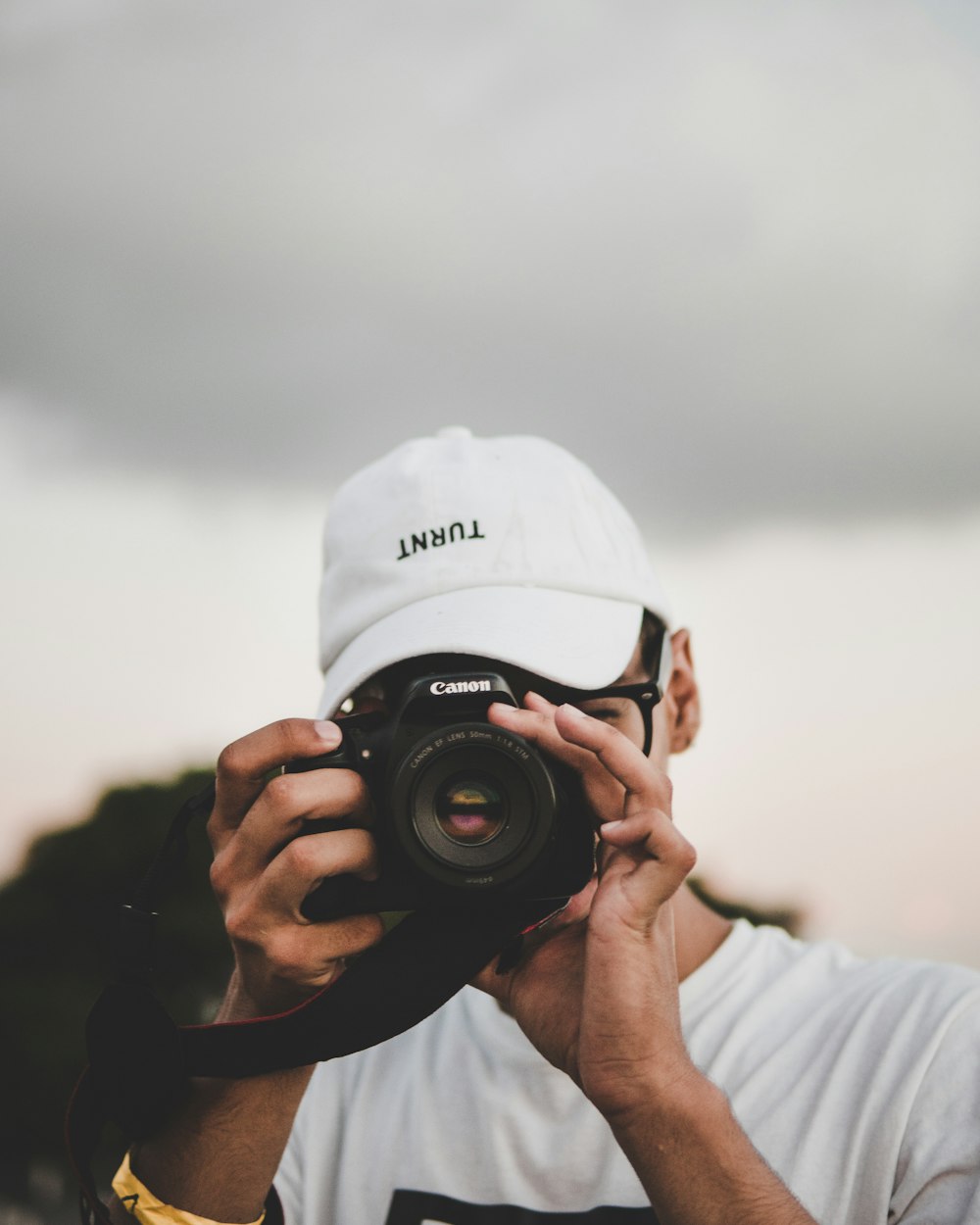 man taking a picture using Canon DSLR camera