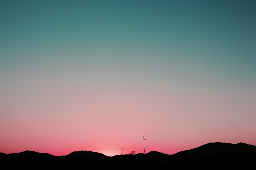 Silhouette von Bergen unter rosa und blauem Himmel