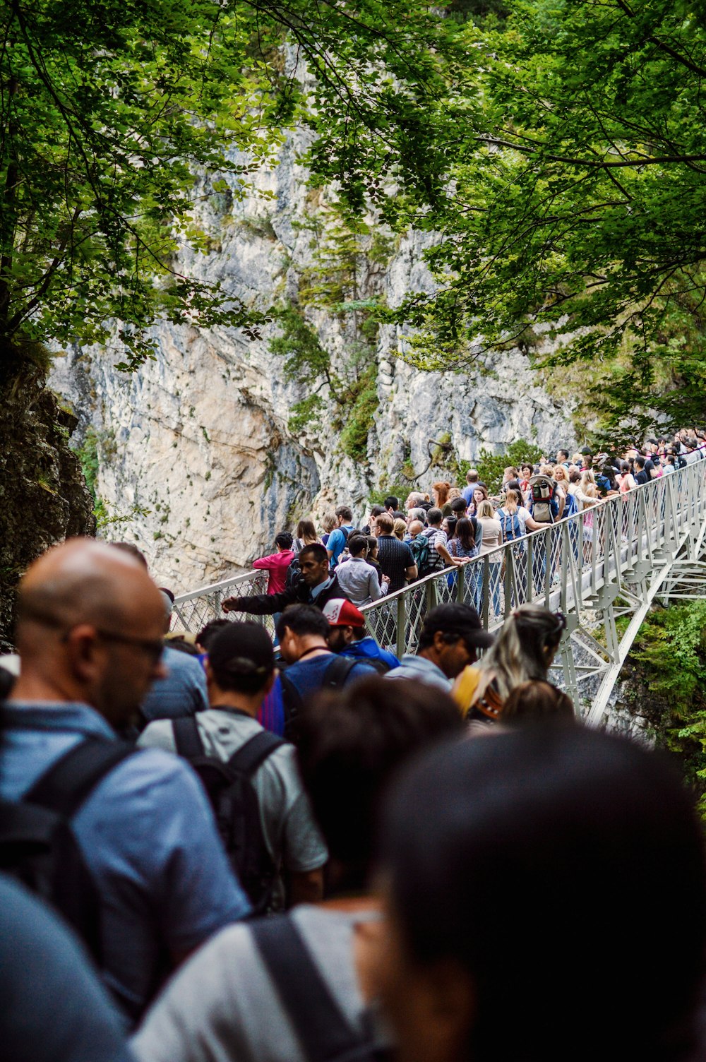 shallow focus photography of people crossing at the bridge