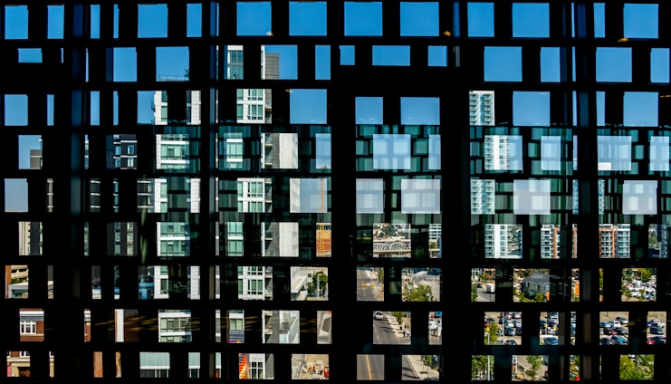Frosted glass panel overlaying a dark, futuristic cityscape with neon blue and violet tech lines weaving through skyscrapers.