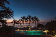 pool surrounded with trees and gazebos