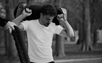 grayscale photography of man holding backpack