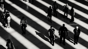 grayscale photo of people on white pavement