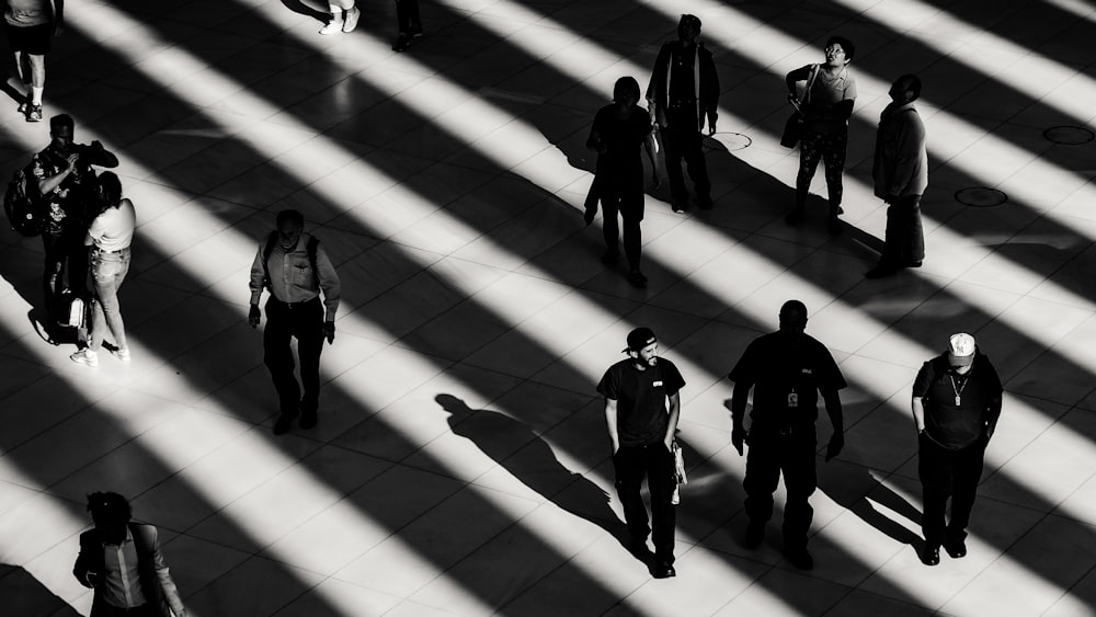 grayscale photo of people on white pavement