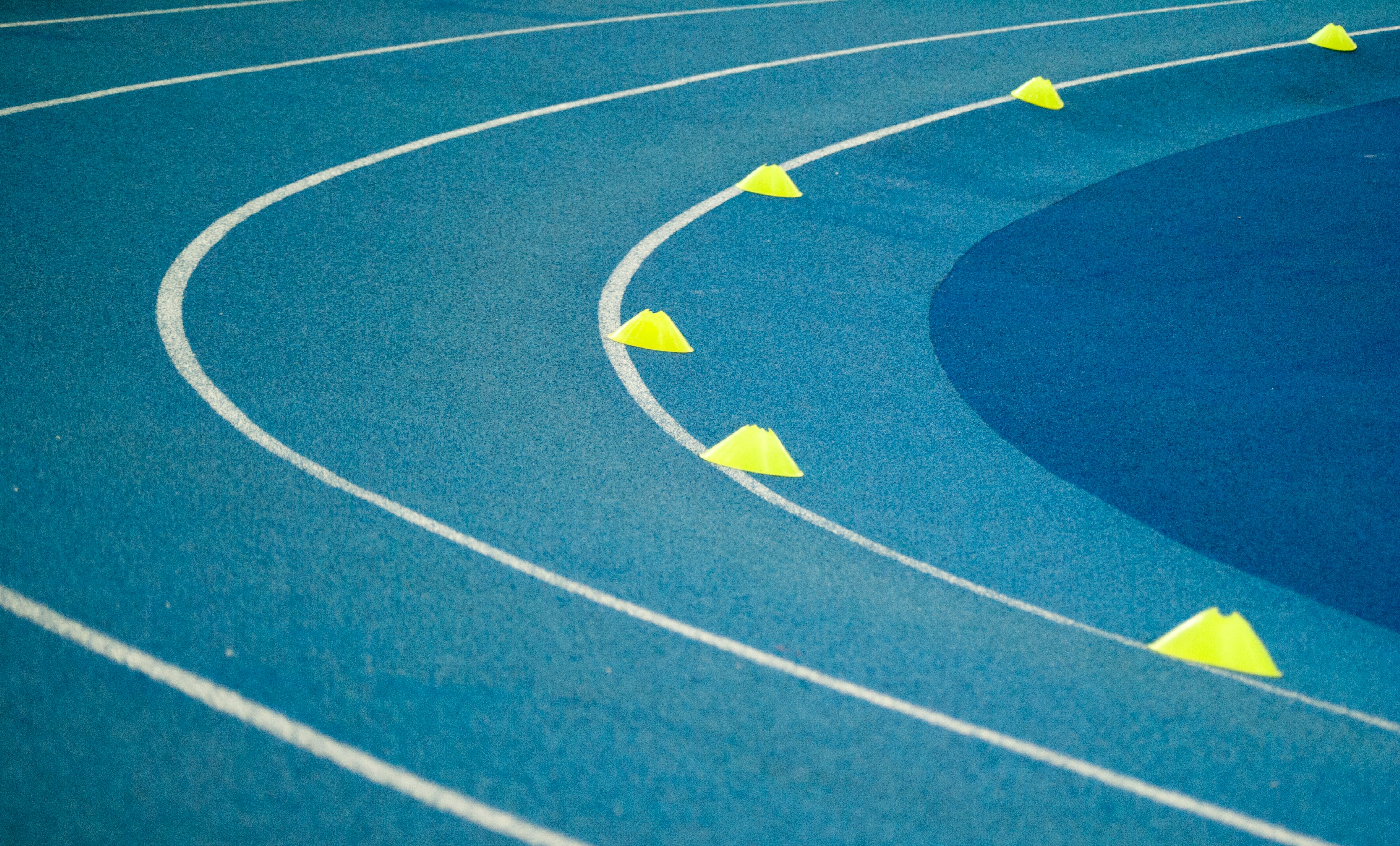 blue curved track field at daytime