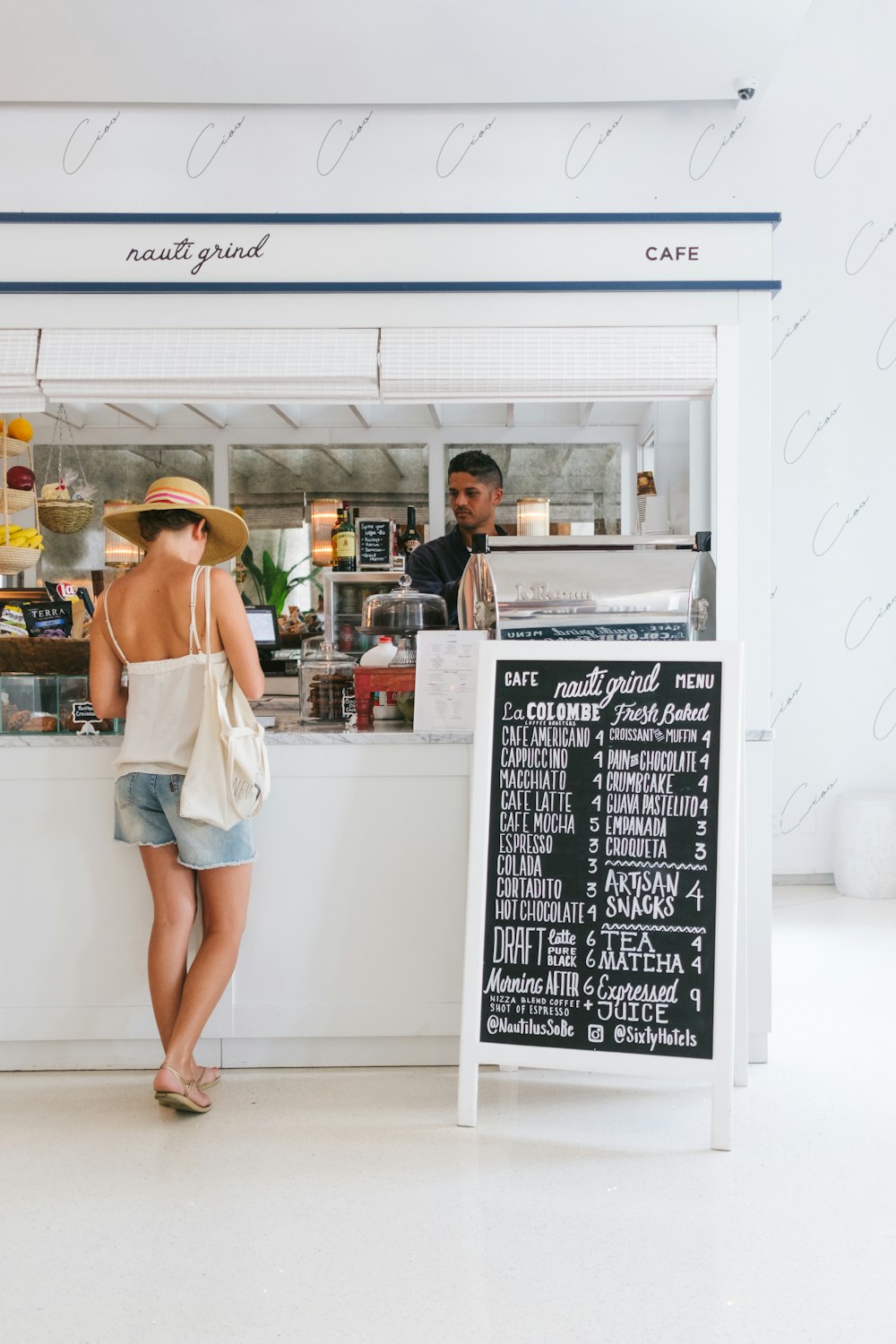 woman with white spaghetti strap top near the bar