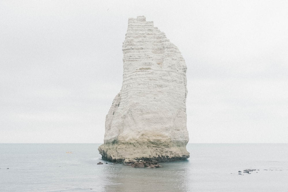 white stone formation in the middle of the sea