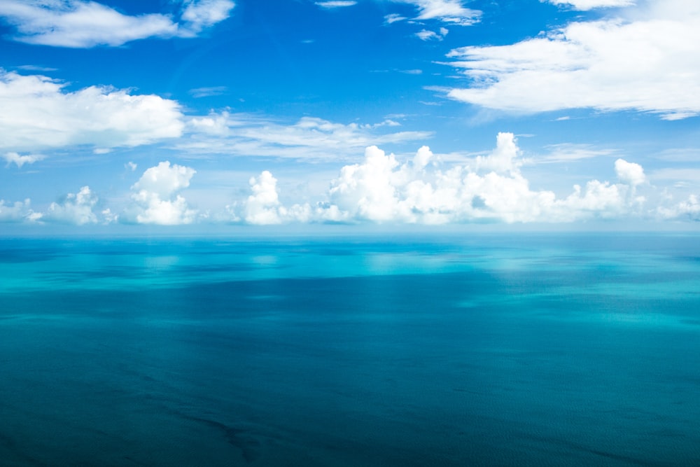 oceano blu sotto cieli nuvolosi blu