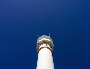 Abstract minimalist design of a lighthouse integrated with financial graphs.