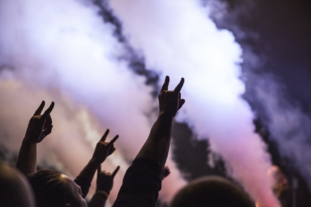 Foto von Personen, die ein Rock-Handzeichen machen