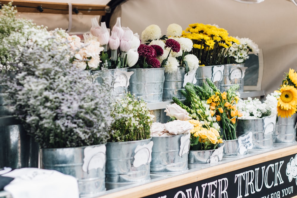 assorted flowers in stainless steel pots