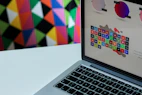 A vibrant laptop screen displaying colorful digital art and design software.