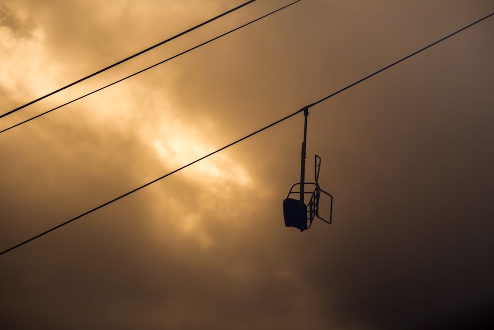 téléphérique noir sous un ciel nuageux pendant la journée