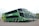 A line of modern double-decker coaches parked side by side in an open area. Each bus features a sleek design with prominent windshields and the word 'Eucatur' on the side. The foremost bus is painted in green with images of jungle foliage, including a jaguar, enhancing its aesthetic appeal.