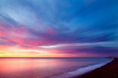 body of water and seashore sunset teams background