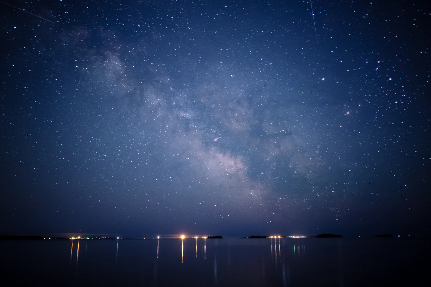 Still water at night under a deep blue sky
