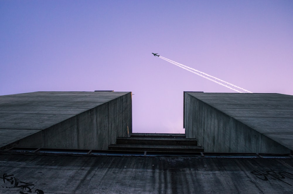 건물 위를 비행하는 비행기의 로우 앵글 사진