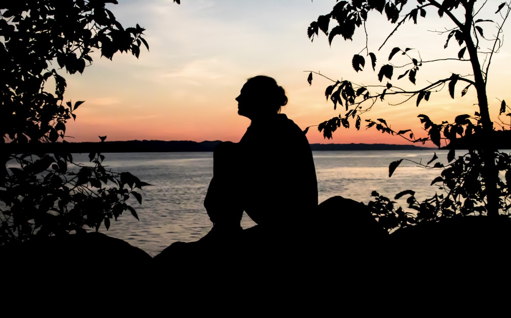 silhouette of woman near green leafed plants