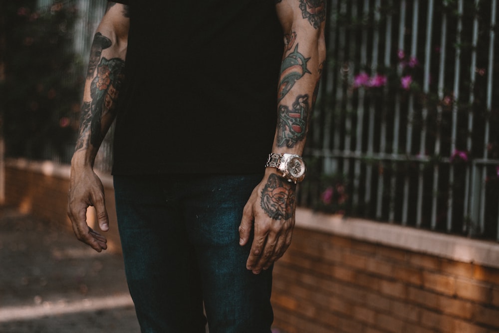 man standing nearby slatted fence