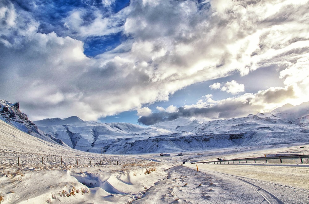 photographie de paysage de montagne enneigée sous ciel nuageux