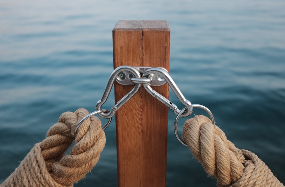 two rope with carbiner hooked on brown wooden post