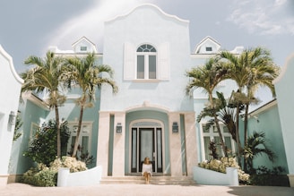A freshly painted elegant home exterior showcasing a deep navy blue with crisp white trim under bright sunlight.