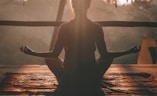 woman doing yoga meditation on brown parquet flooring