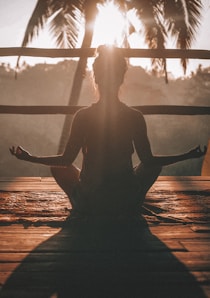 woman doing yoga meditation on brown parquet flooring