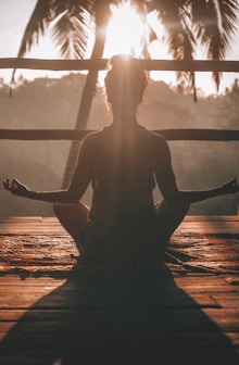 woman doing yoga meditation on brown parquet flooring