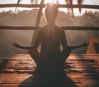 woman doing yoga meditation on brown parquet flooring