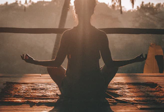 woman doing yoga meditation on brown parquet flooring