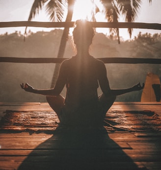 woman doing yoga meditation on brown parquet flooring