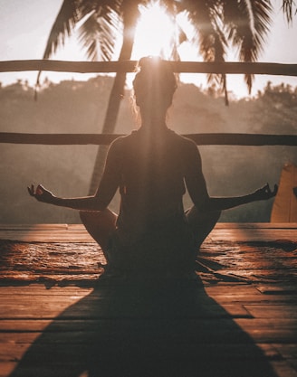 woman doing yoga meditation on brown parquet flooring