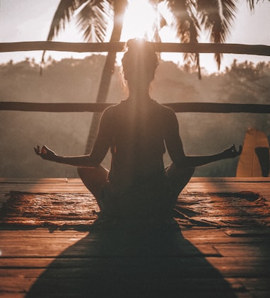 woman doing yoga meditation on brown parquet flooring