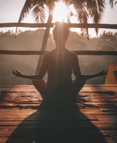 woman doing yoga meditation on brown parquet flooring